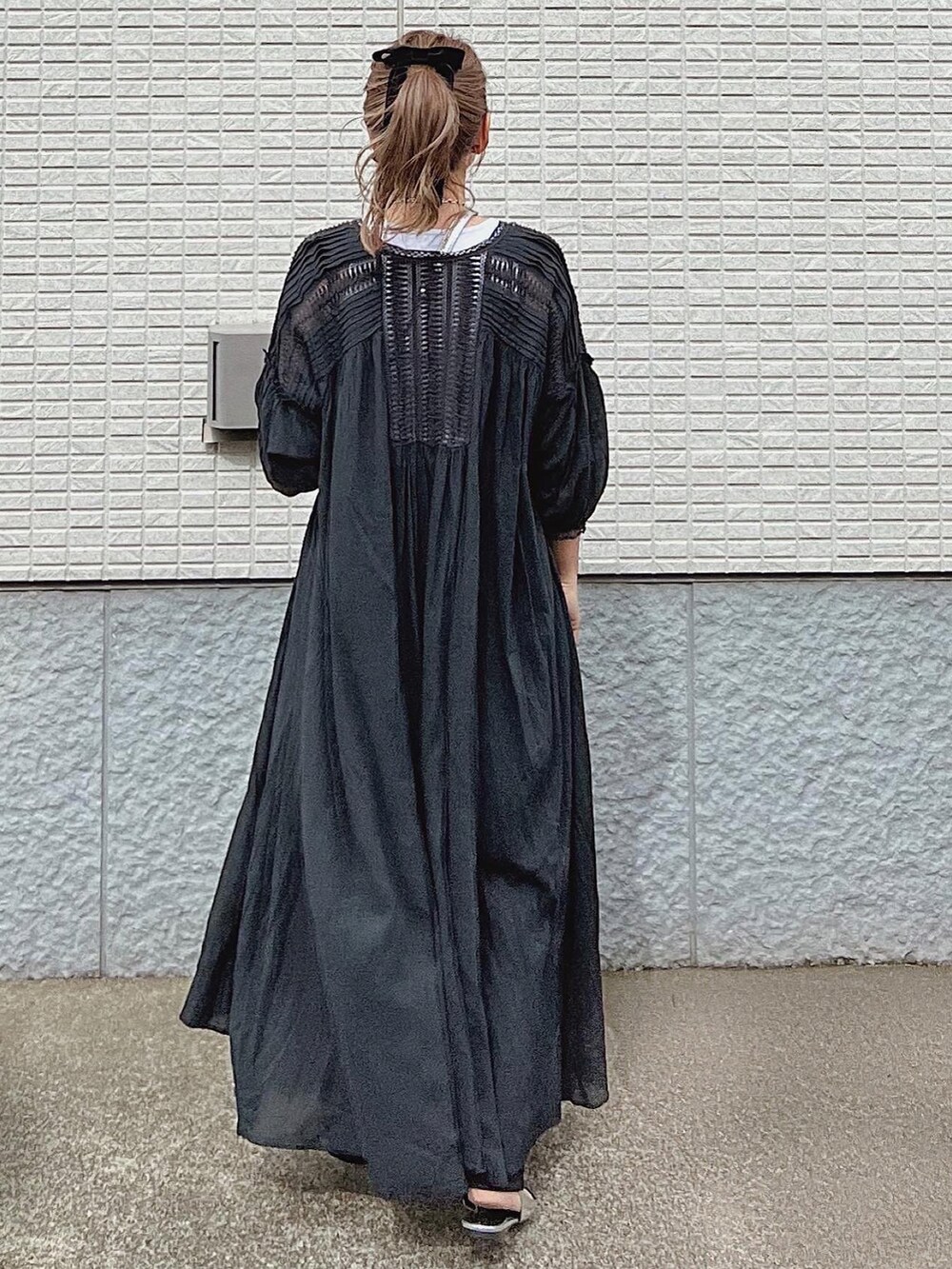 シルバー系のショルダーバッグ、シルバー系のサンダル、ブラック系のシャツワンピースを着用したレディースの春コーディネートの2枚目の写真