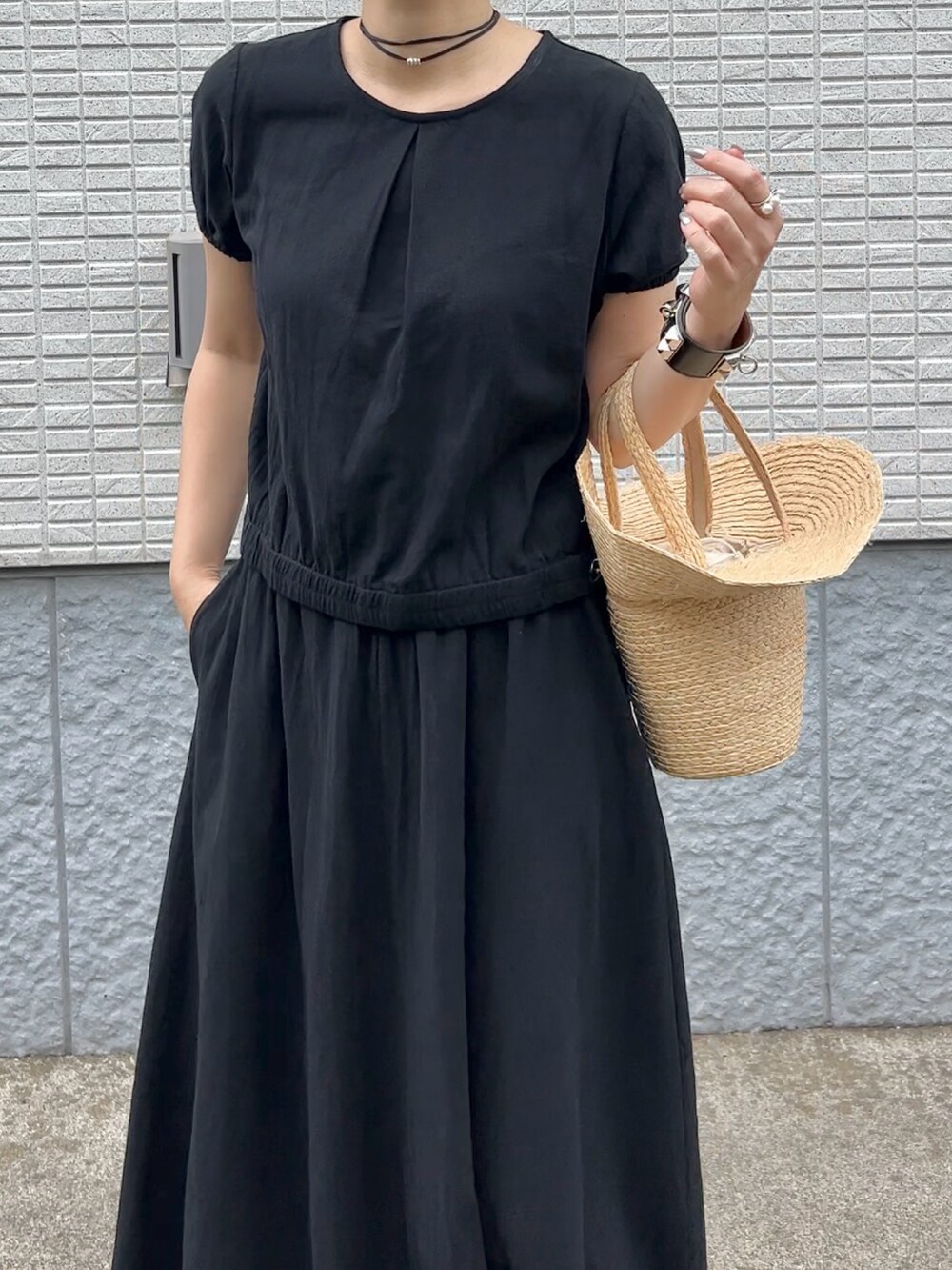 ブラック系のセットアップ、ベージュ系のかごバッグ、シルバー系のパンプスを着用したレディースの春コーディネートの3枚目の写真