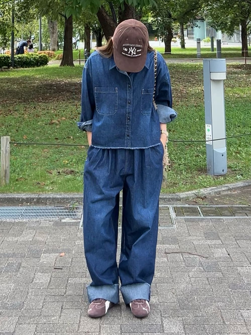 ブルー系のデニムパンツ、ブルー系のシャツ/ブラウス、ブラウン系のスニーカーを着用したレディースの秋コーディネートの2枚目の写真