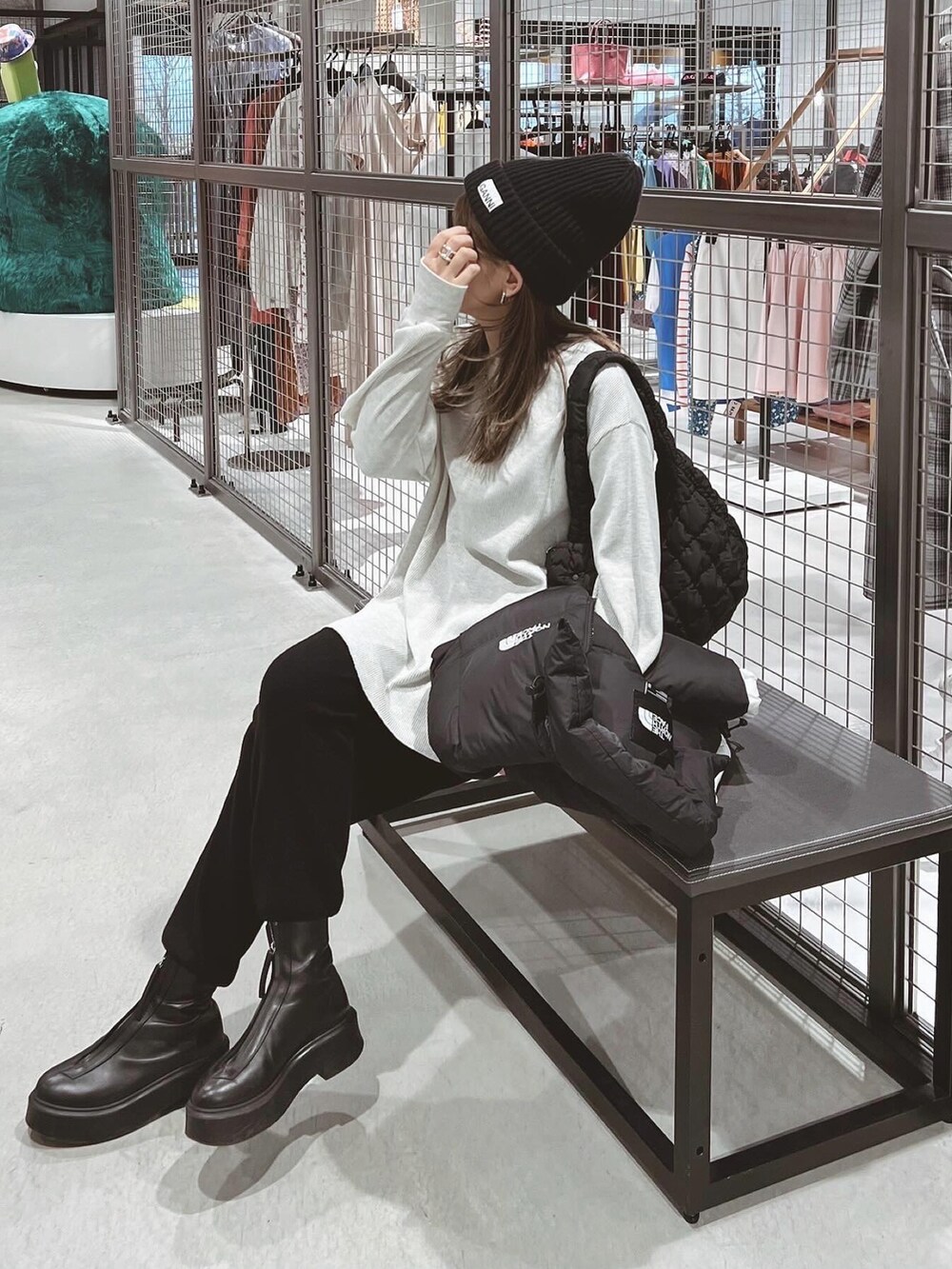 ホワイト系のTシャツ/カットソー、ブラック系のブーツ、ブラック系のニットキャップ/ビーニーを着用したレディースの冬コーディネートの3枚目の写真