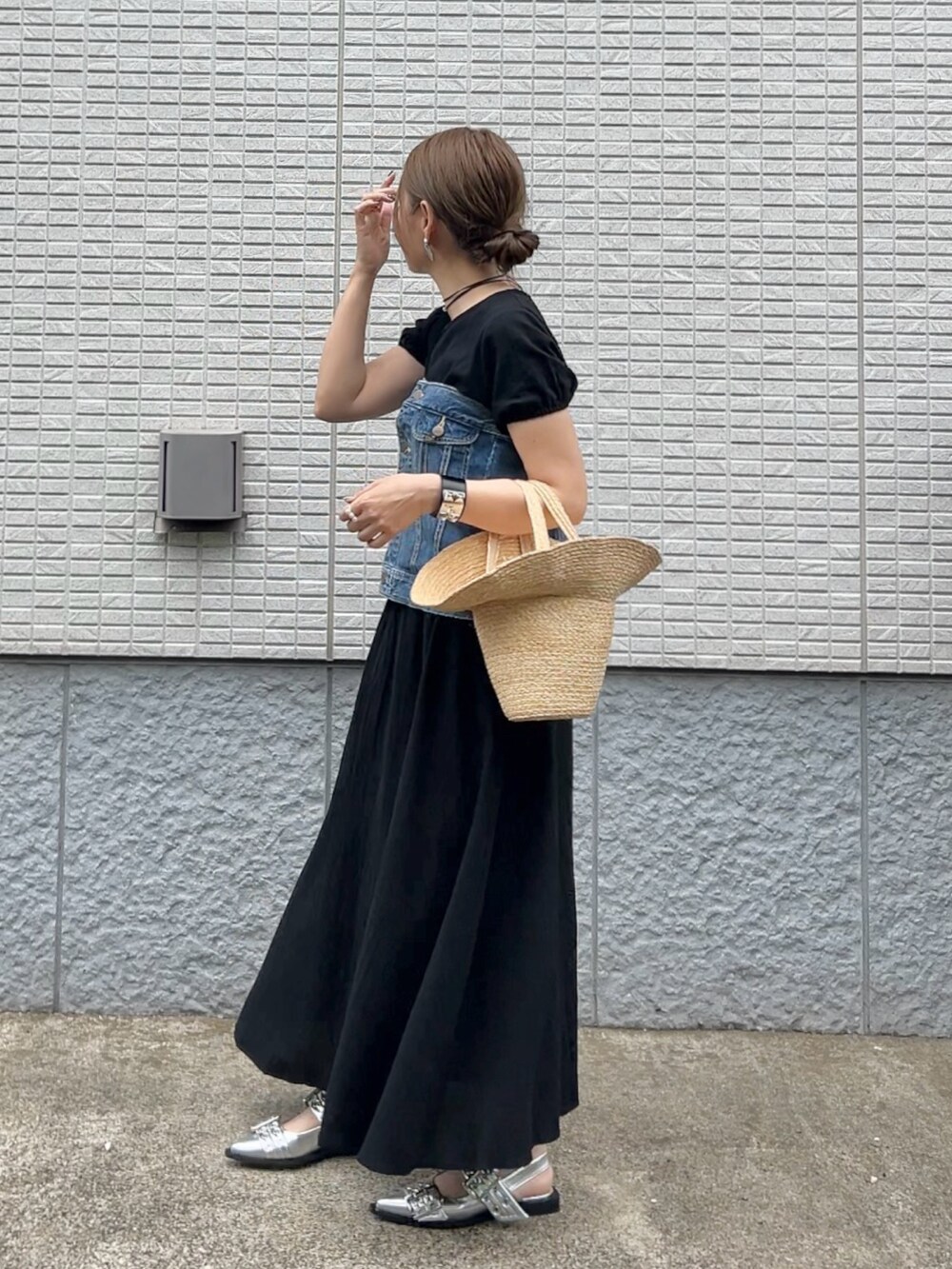 ブラック系のセットアップ、ベージュ系のかごバッグ、シルバー系のパンプスを着用したレディースの春コーディネートの4枚目の写真