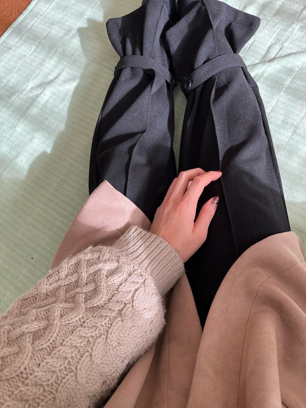 ベージュ系のベスト、ブラック系のパンツを着用したレディースの冬コーディネートの2枚目の写真