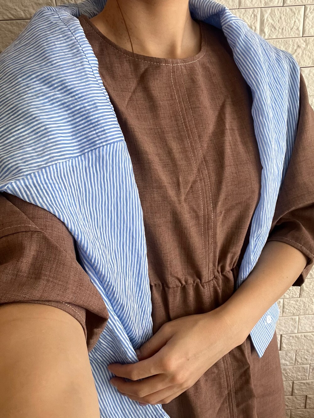 ブラウン系のワンピース/ドレス、ホワイト系のベスト、ブラック系のスニーカーを着用したレディースの夏コーディネートの2枚目の写真