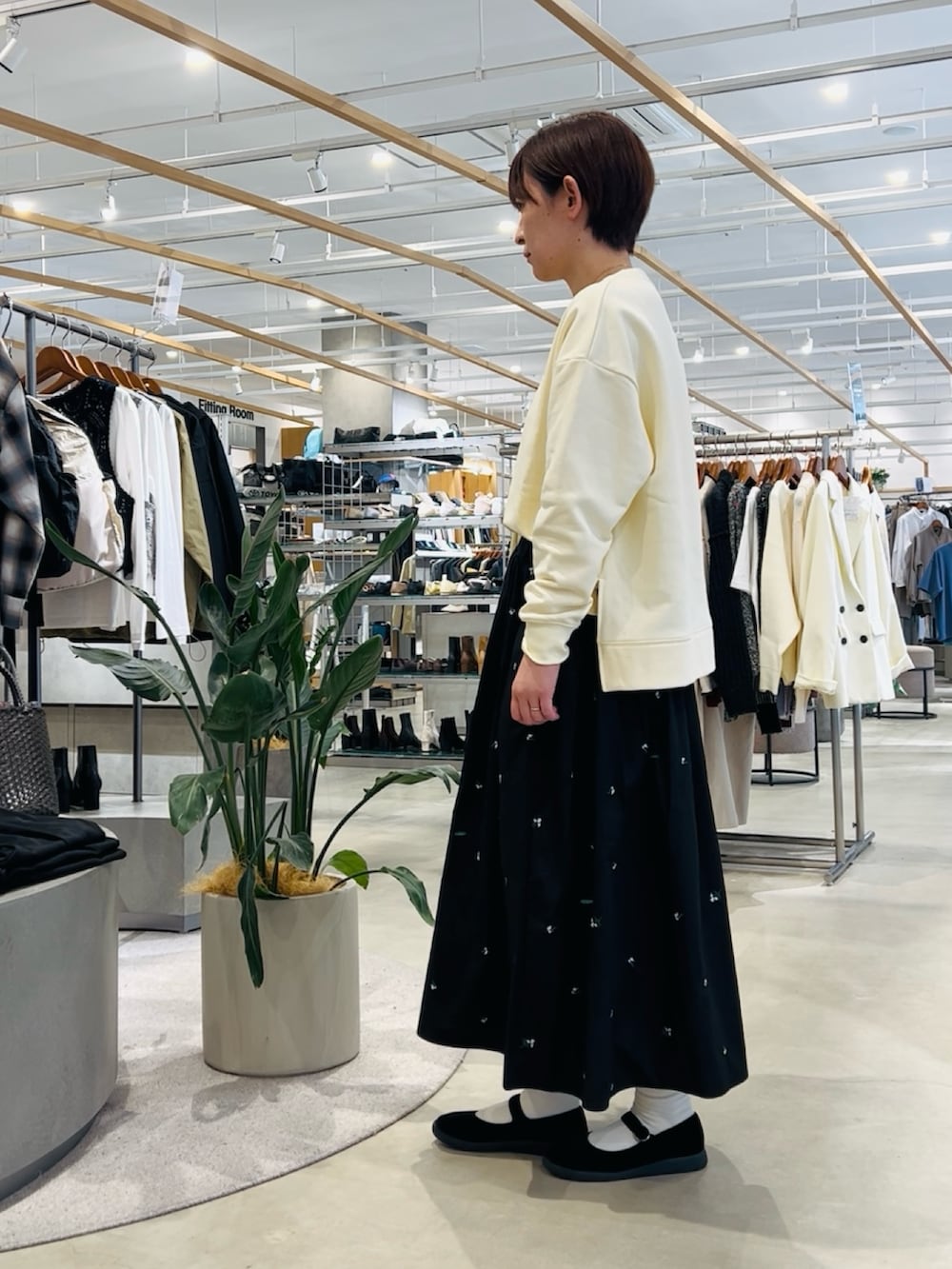 ホワイト系のTシャツ/カットソー、グレー系のトートバッグ、ブラック系のスカートを着用したレディースの春コーディネートの2枚目の写真