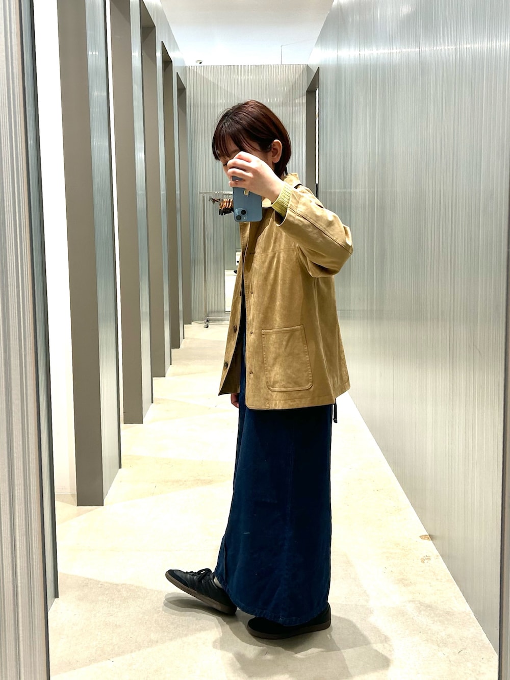 グリーン系のニット/セーター、ベージュ系のその他アウター、ブルー系のワンピースを着用したレディースの冬コーディネートの2枚目の写真