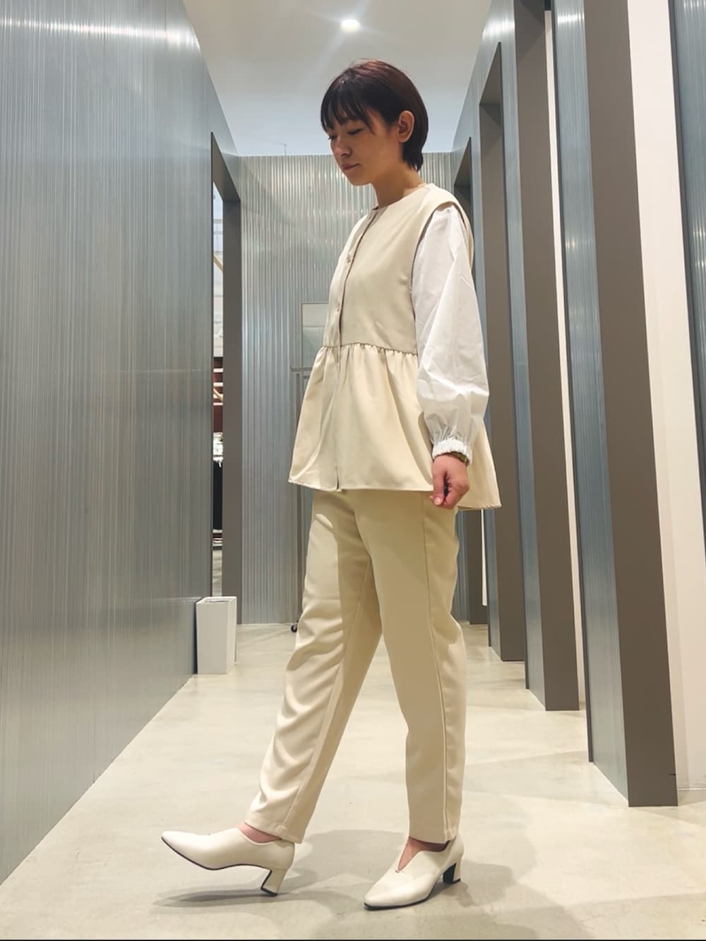 ホワイト系のセットアップ、ホワイト系のパンプスを着用したレディースの冬コーディネートの3枚目の写真