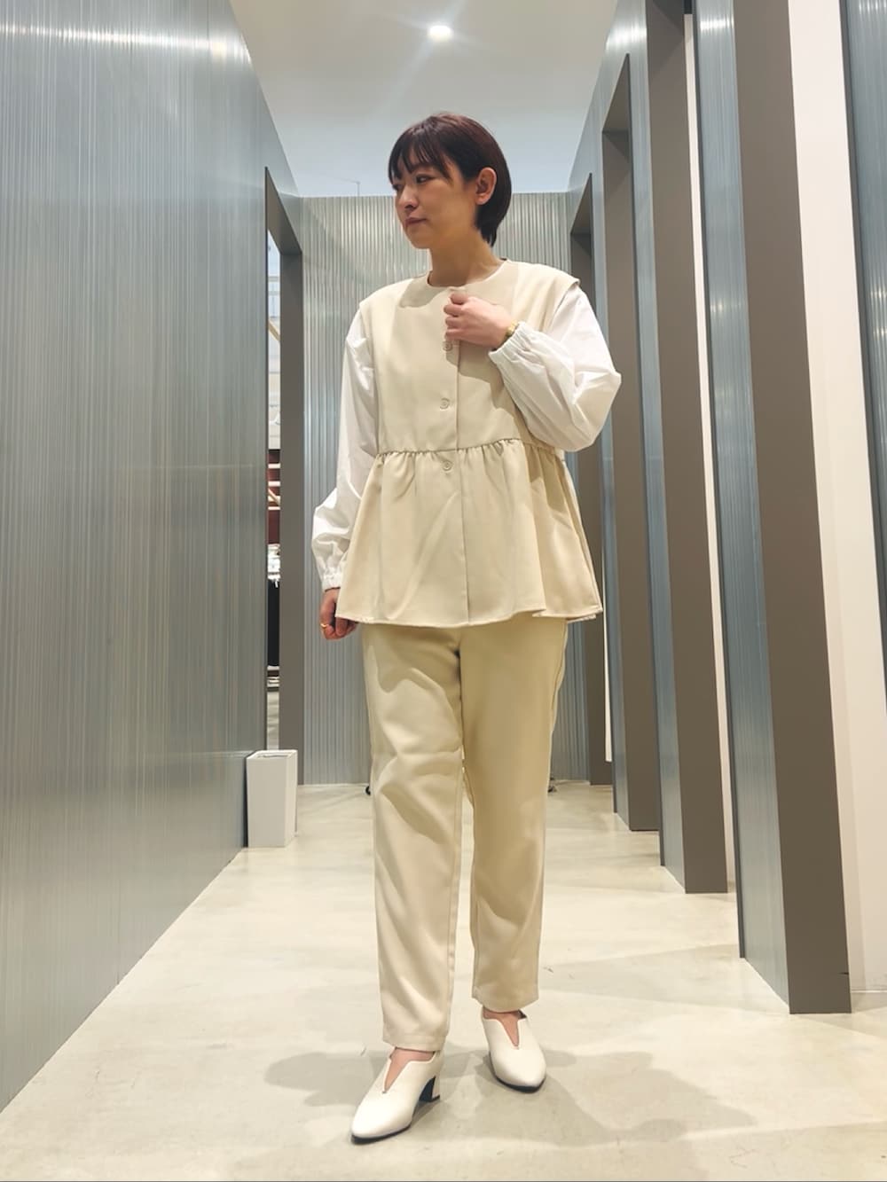 ホワイト系のセットアップ、ホワイト系のパンプスを着用したレディースの冬コーディネートの2枚目の写真