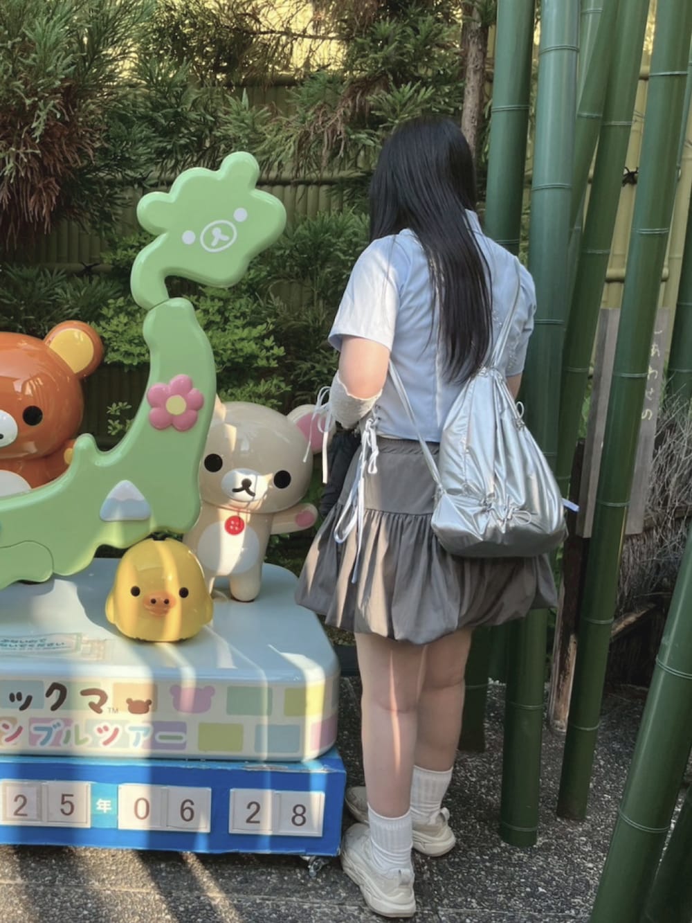 グレー系のスカート、ホワイト系のスニーカー、ブルー系のシャツ/ブラウスを着用したレディースの夏コーディネートの2枚目の写真