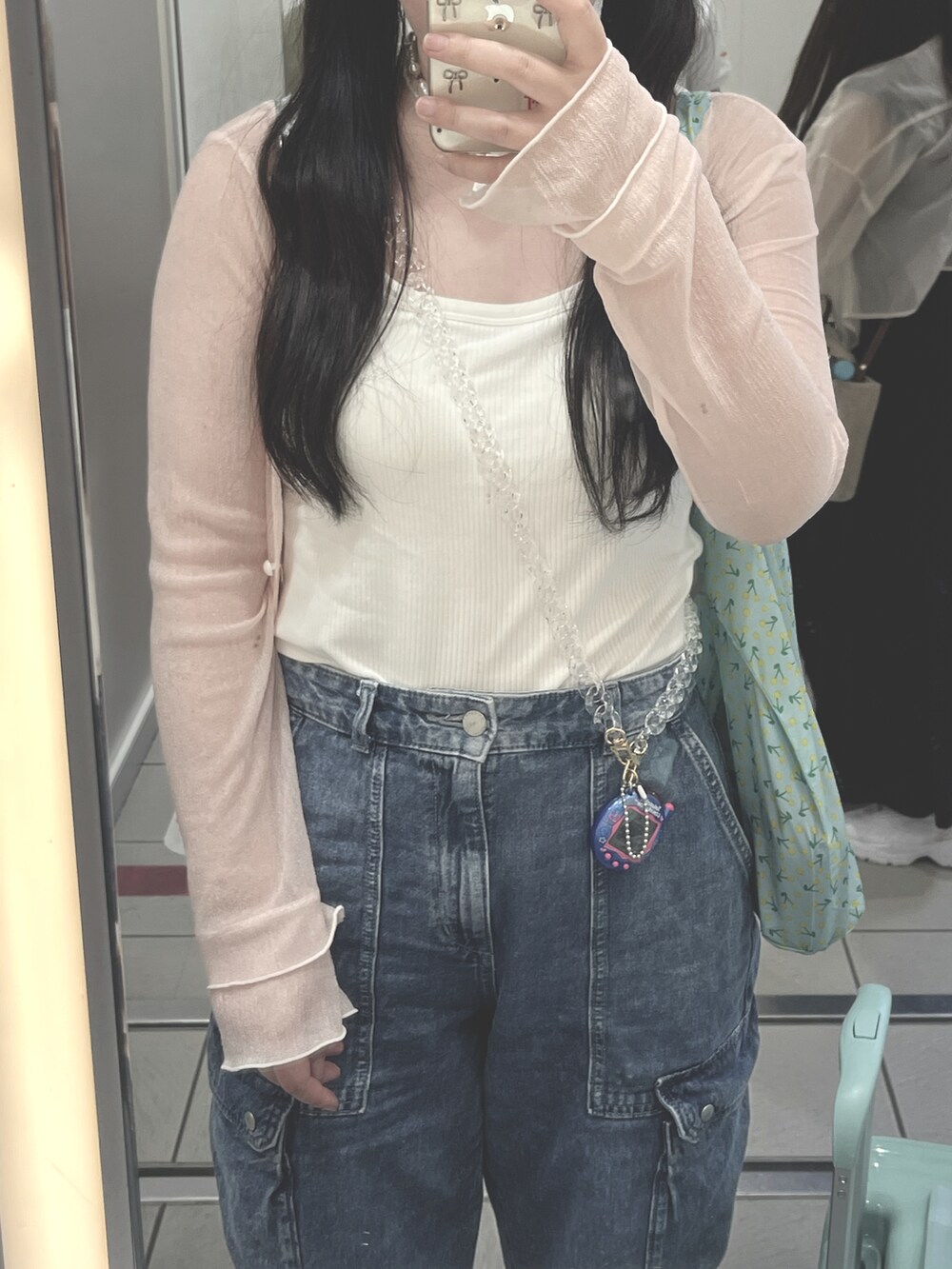 ホワイト系のタンクトップ、ピンク系のカーディガン/ボレロ、ブルー系のデニムパンツを着用したレディースの夏コーディネートの3枚目の写真