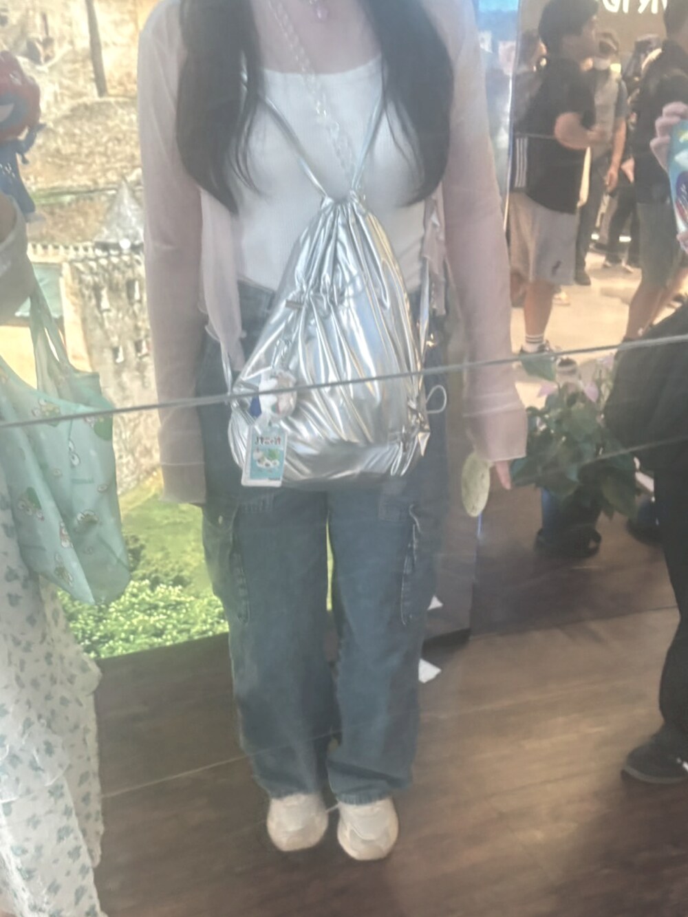 ホワイト系のタンクトップ、ピンク系のカーディガン/ボレロ、ブルー系のデニムパンツを着用したレディースの夏コーディネートの2枚目の写真