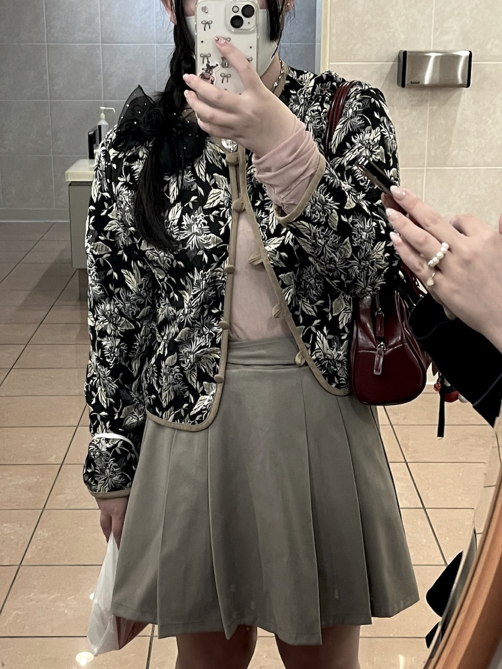 ピンク系のTシャツ/カットソー、ブラック系のブルゾン、グレー系のスカートを着用したレディースの春コーディネートの4枚目の写真