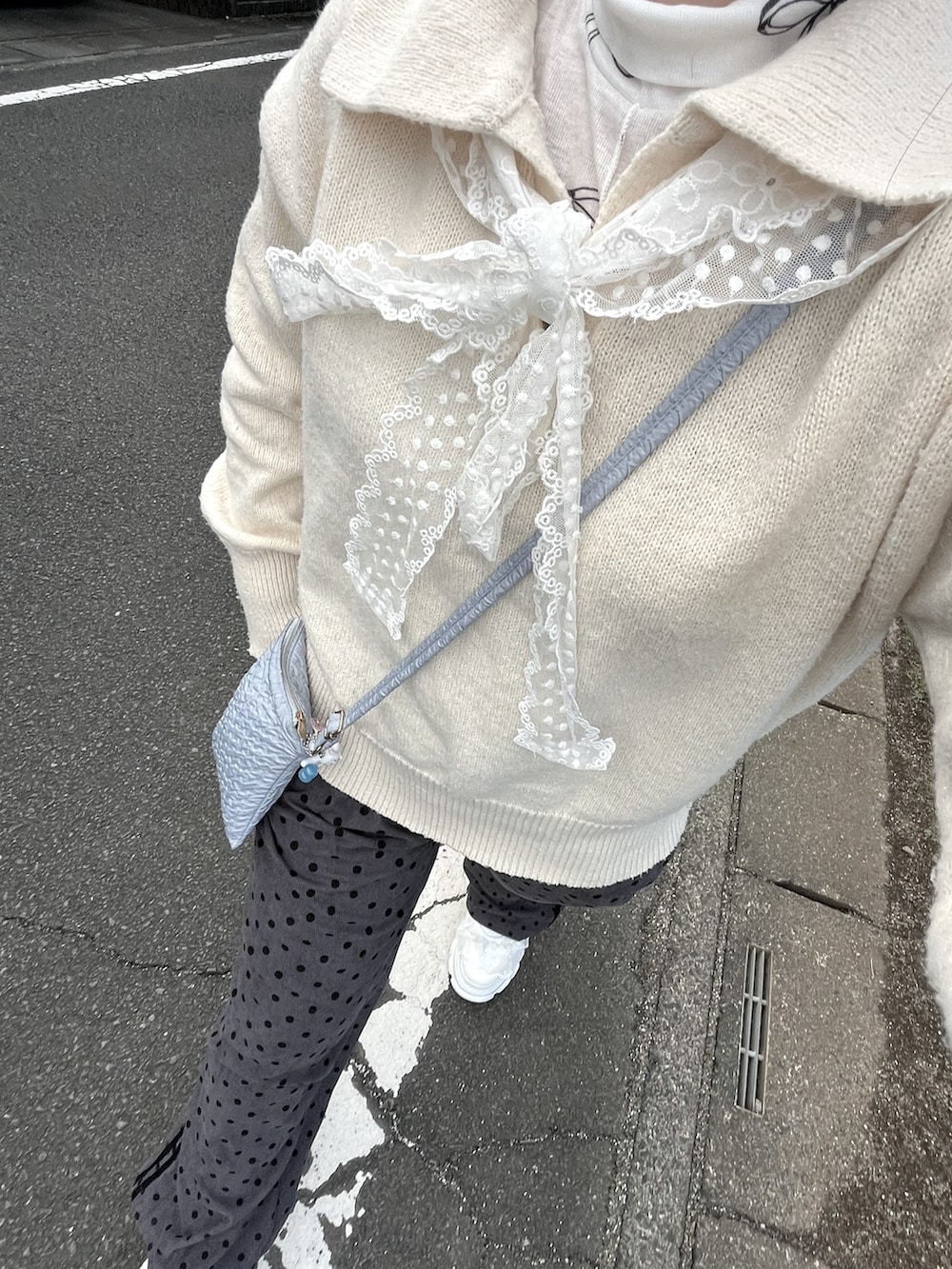 ホワイト系のニット/セーター、ホワイト系のスニーカーを着用したレディースの秋コーディネートの2枚目の写真