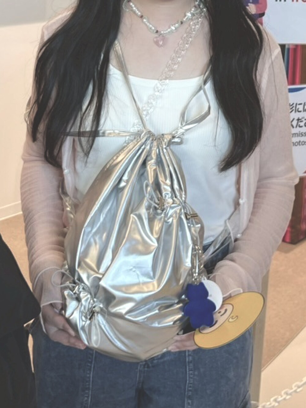 ホワイト系のタンクトップ、ピンク系のカーディガン/ボレロ、ブルー系のデニムパンツを着用したレディースの夏コーディネートの4枚目の写真