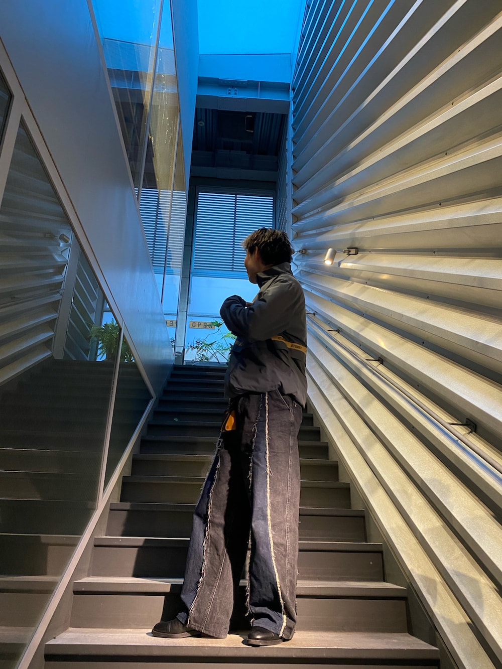 ブラック系のデニムパンツ、グリーン系のトップス、ブラック系のローファーを着用したメンズの冬コーディネートの2枚目の写真