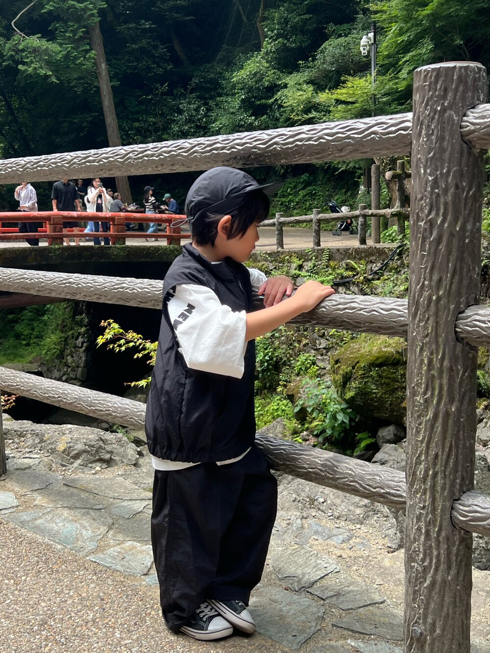 ブラック系のカーゴパンツ、ブラック系のベスト、ホワイト系のTシャツ/カットソーを着用したキッズの夏コーディネートの3枚目の写真