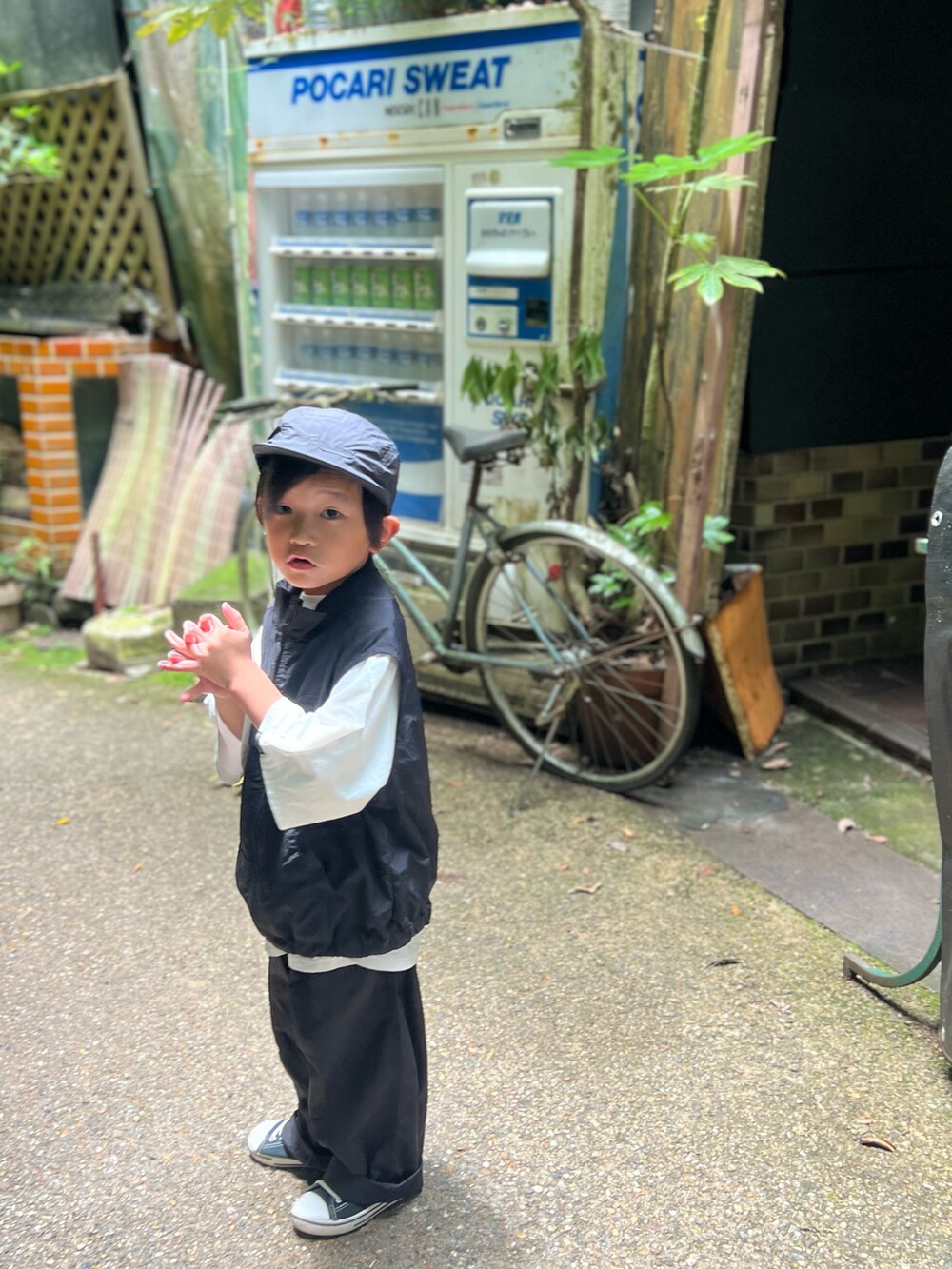 ブラック系のカーゴパンツ、ブラック系のベスト、ホワイト系のTシャツ/カットソーを着用したキッズの夏コーディネートの2枚目の写真