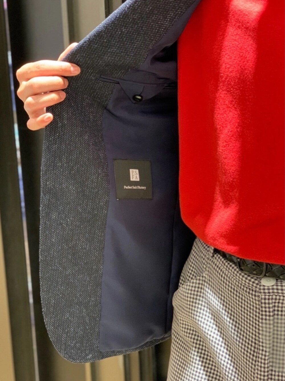 ブルー系のテーラードジャケット、レッド系のニット/セーターを着用したメンズの春コーディネートの3枚目の写真