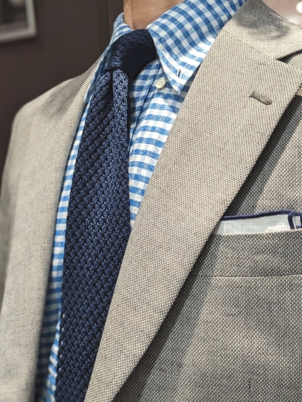 ブルー系のネクタイ、ベージュ系のテーラードジャケットを着用したメンズの春コーディネートの2枚目の写真