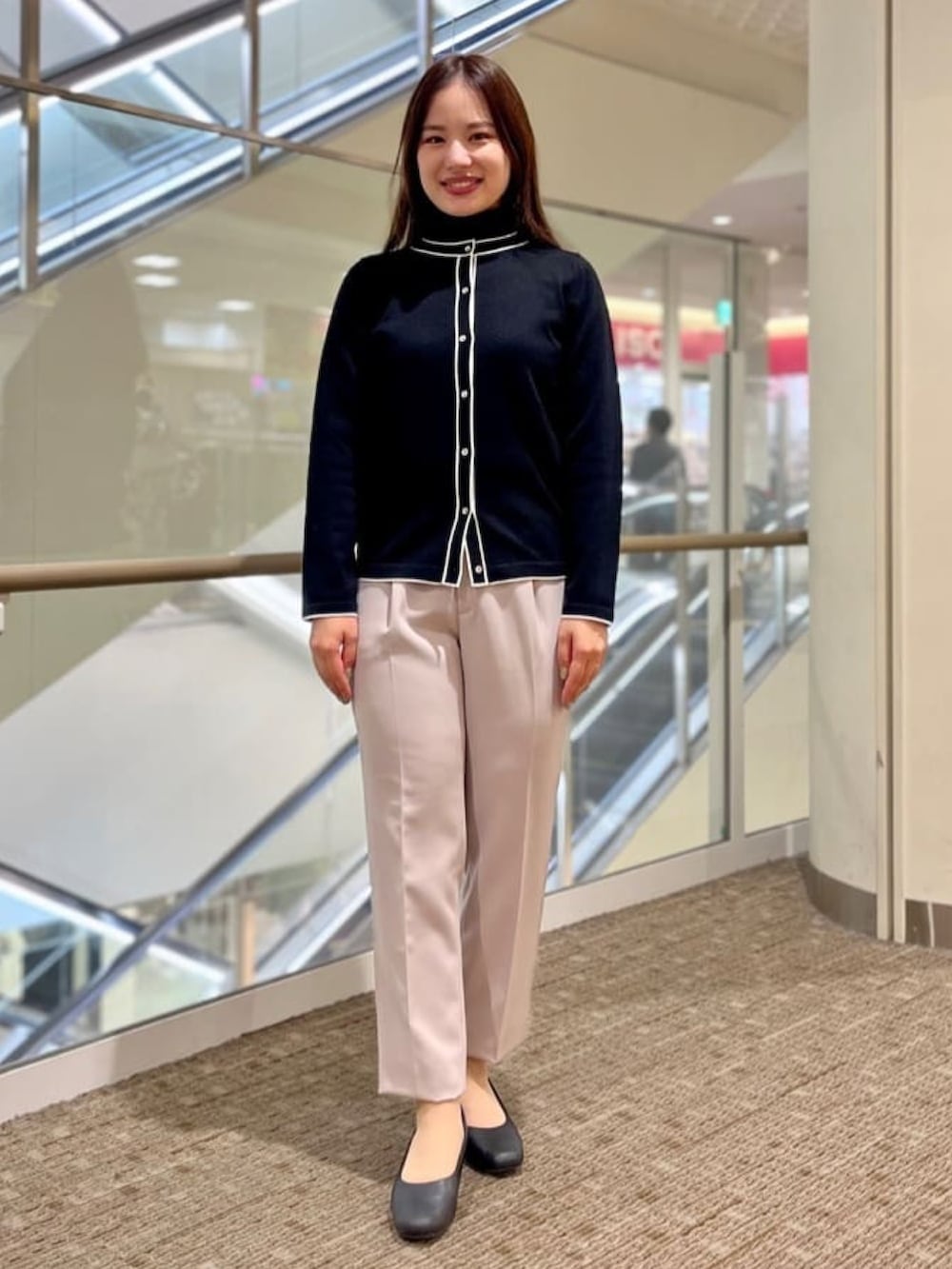 ブラック系のニット/セーター、ブラック系のカーディガン/ボレロ、ベージュ系のスーツパンツを着用したレディースの冬コーディネートの2枚目の写真