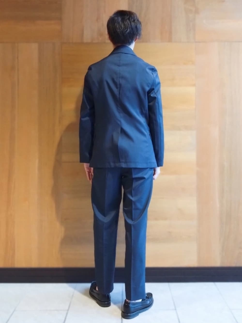 ブルー系のテーラードジャケット、ブルー系のスラックスを着用したメンズの春コーディネートの2枚目の写真