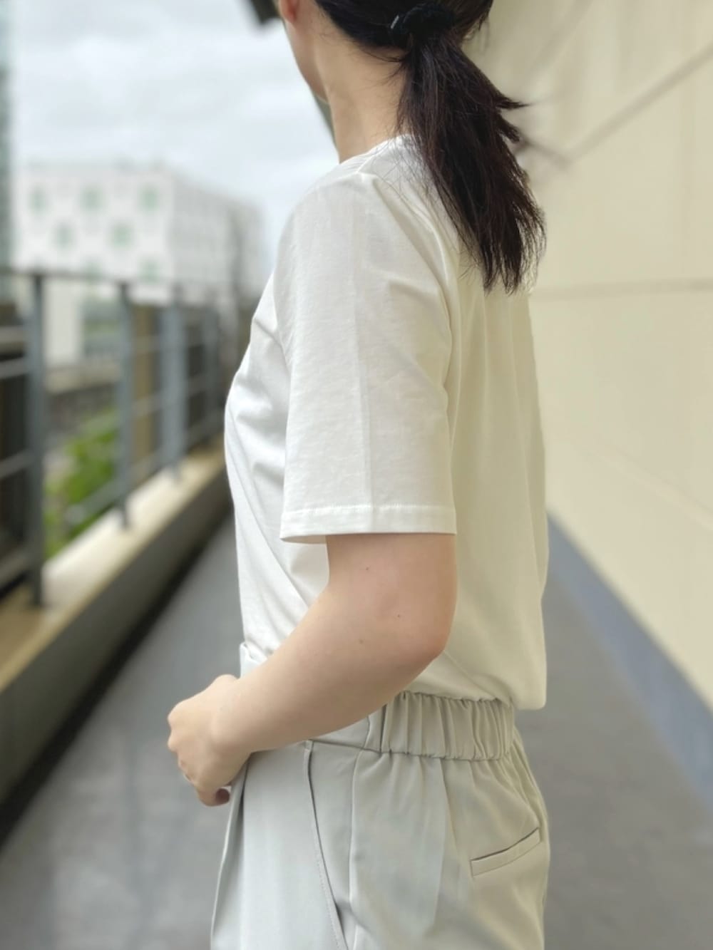 ホワイト系のTシャツ/カットソー、グリーン系のスラックスを着用したレディースの夏コーディネートの3枚目の写真