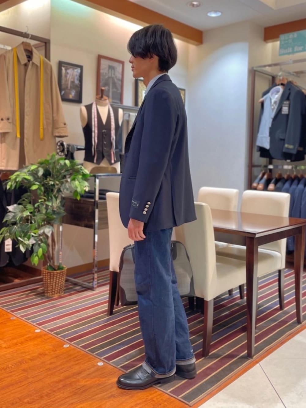 グレー系のビジネスバッグ、ブルー系のテーラードジャケット、ブルー系のビジネスシャツを着用したメンズの冬コーディネートの2枚目の写真