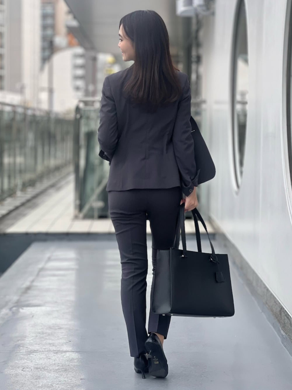 グレー系のスーツジャケット、グレー系のスーツパンツ、ブルー系のニット/セーターを着用したレディースの春コーディネートの2枚目の写真