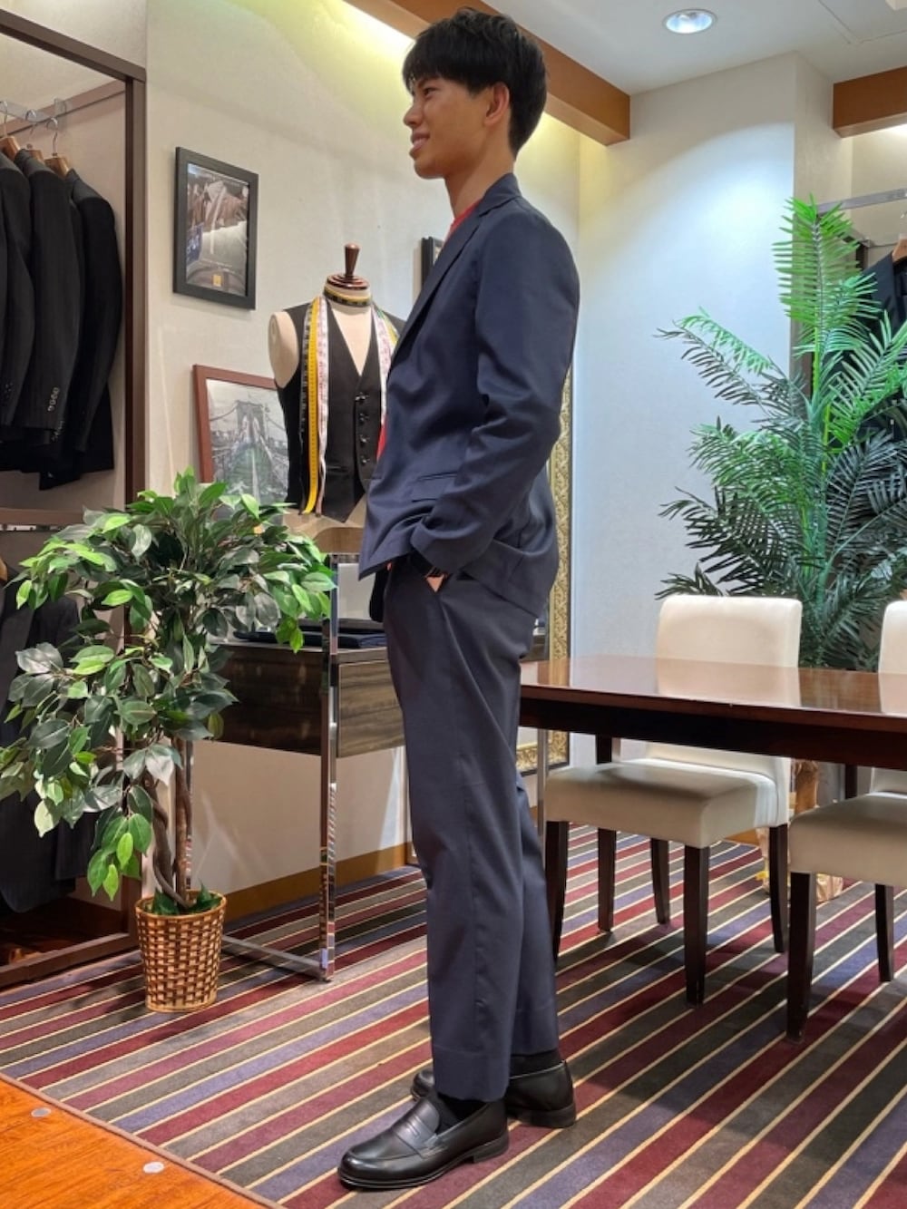 ブルー系のテーラードジャケット、レッド系のニット/セーター、ブルー系のスラックスを着用したメンズの春コーディネートの2枚目の写真