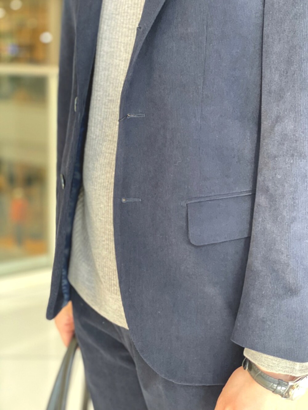 ブルー系のテーラードジャケット、ブルー系のスラックス、ブラック系のトートバッグを着用したメンズの冬コーディネートの3枚目の写真