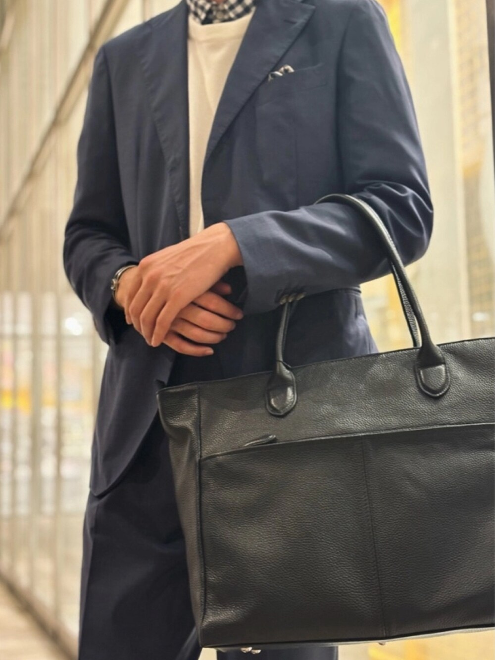 ブラック系のトートバッグを着用したメンズの春コーディネートの2枚目の写真