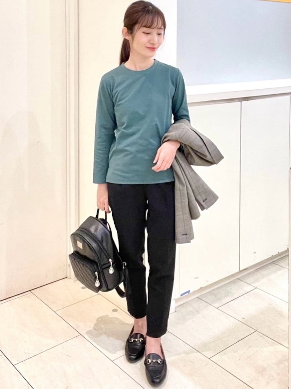 グリーン系のシャツ/ブラウス、ブラック系のスラックス、ブラック系のローファーを着用したレディースの冬コーディネートの2枚目の写真