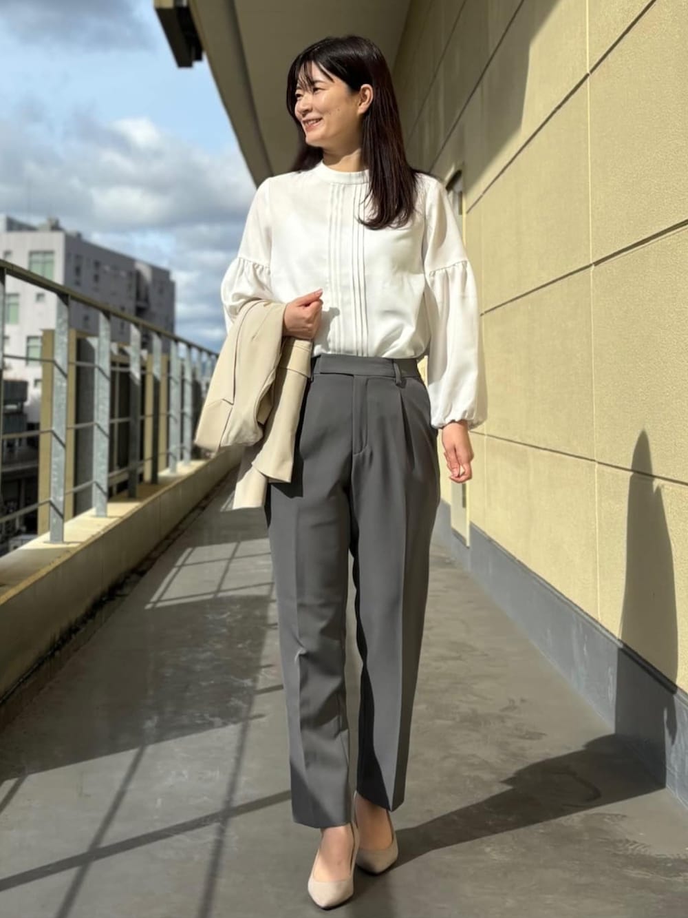ベージュ系のスーツジャケット、ホワイト系のシャツ/ブラウス、グレー系のスーツパンツを着用したレディースの春コーディネートの4枚目の写真