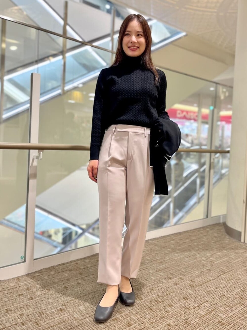 ブラック系のニット/セーター、ブラック系のカーディガン/ボレロ、ベージュ系のスーツパンツを着用したレディースの冬コーディネートの3枚目の写真