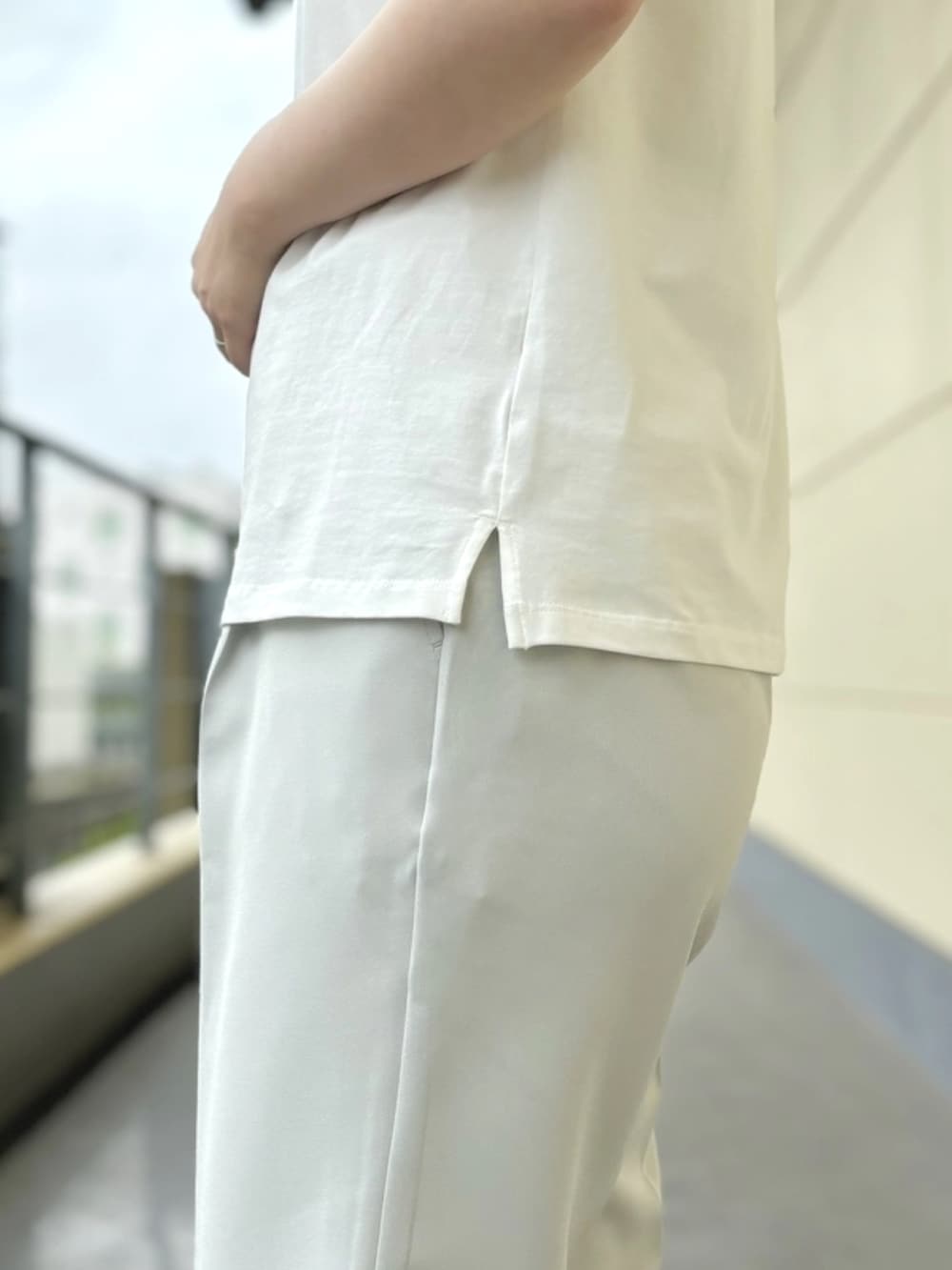 ホワイト系のTシャツ/カットソー、グリーン系のスラックスを着用したレディースの夏コーディネートの4枚目の写真