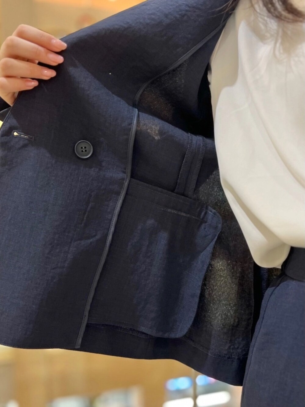 ブルー系のスーツジャケット、ホワイト系のシャツ/ブラウス、ブルー系のスーツパンツを着用したレディースの春コーディネートの5枚目の写真