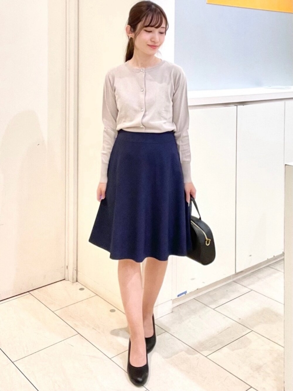 ホワイト系のシャツ/ブラウス、ベージュ系のカーディガン/ボレロを着用したレディースの春コーディネートの3枚目の写真