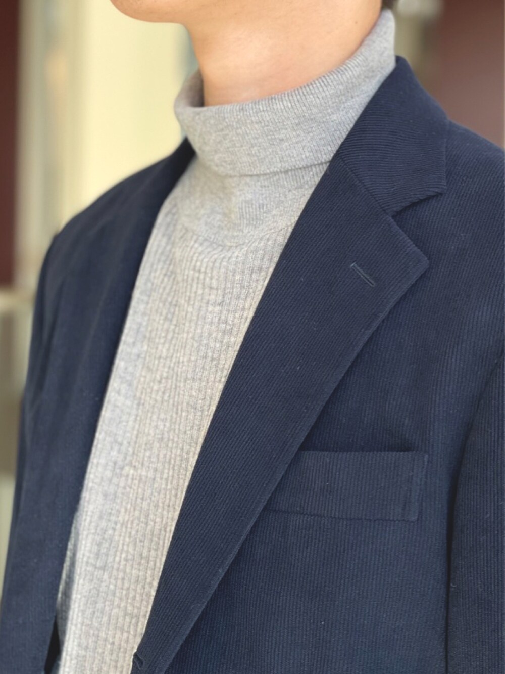 ブルー系のテーラードジャケット、ブルー系のスラックス、ブラック系のトートバッグを着用したメンズの冬コーディネートの2枚目の写真