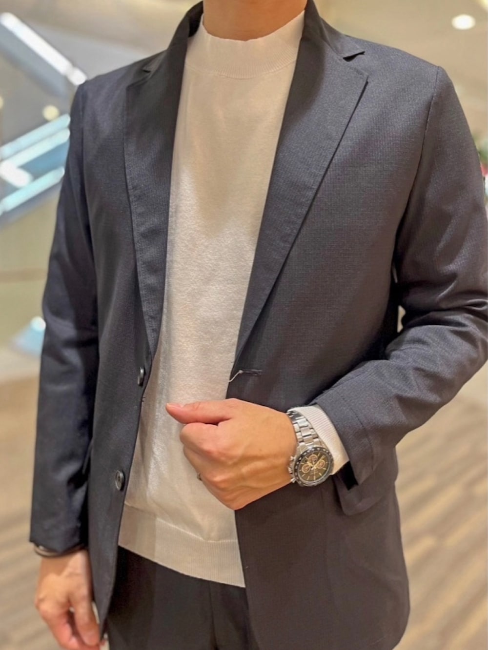 ホワイト系のニット/セーター、ブルー系のテーラードジャケット、ブルー系のスラックスを着用したメンズの春コーディネートの3枚目の写真