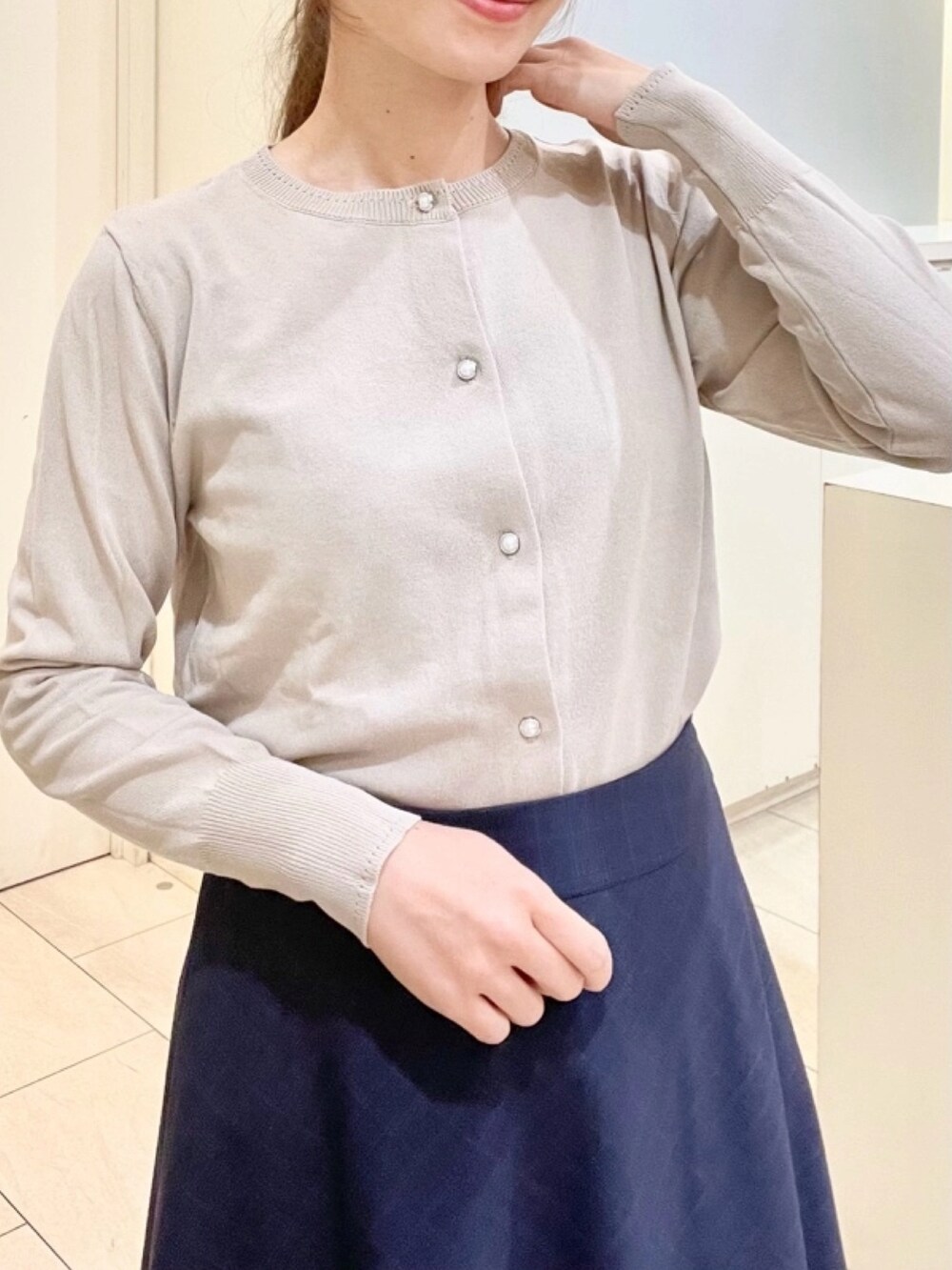 ホワイト系のシャツ/ブラウス、ベージュ系のカーディガン/ボレロを着用したレディースの春コーディネートの4枚目の写真