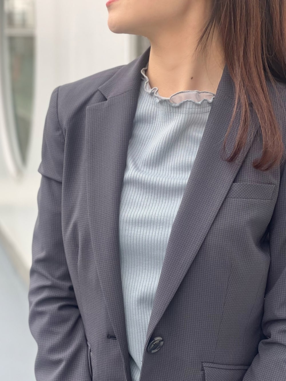 グレー系のスーツジャケット、グレー系のスーツパンツ、ブルー系のニット/セーターを着用したレディースの春コーディネートの3枚目の写真