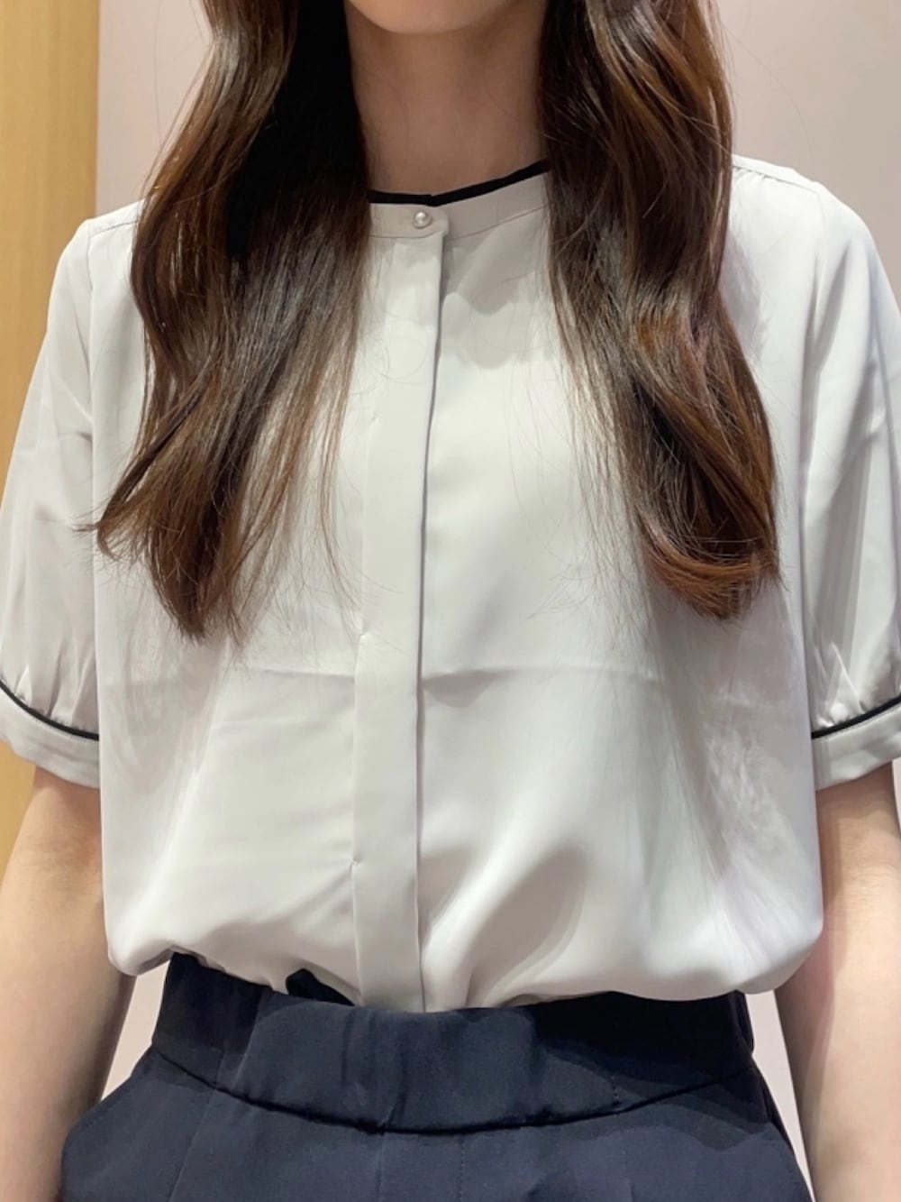 ベージュ系のシャツ/ブラウス、ブルー系のスラックス、ブラック系のトートバッグを着用したレディースの夏コーディネートの3枚目の写真