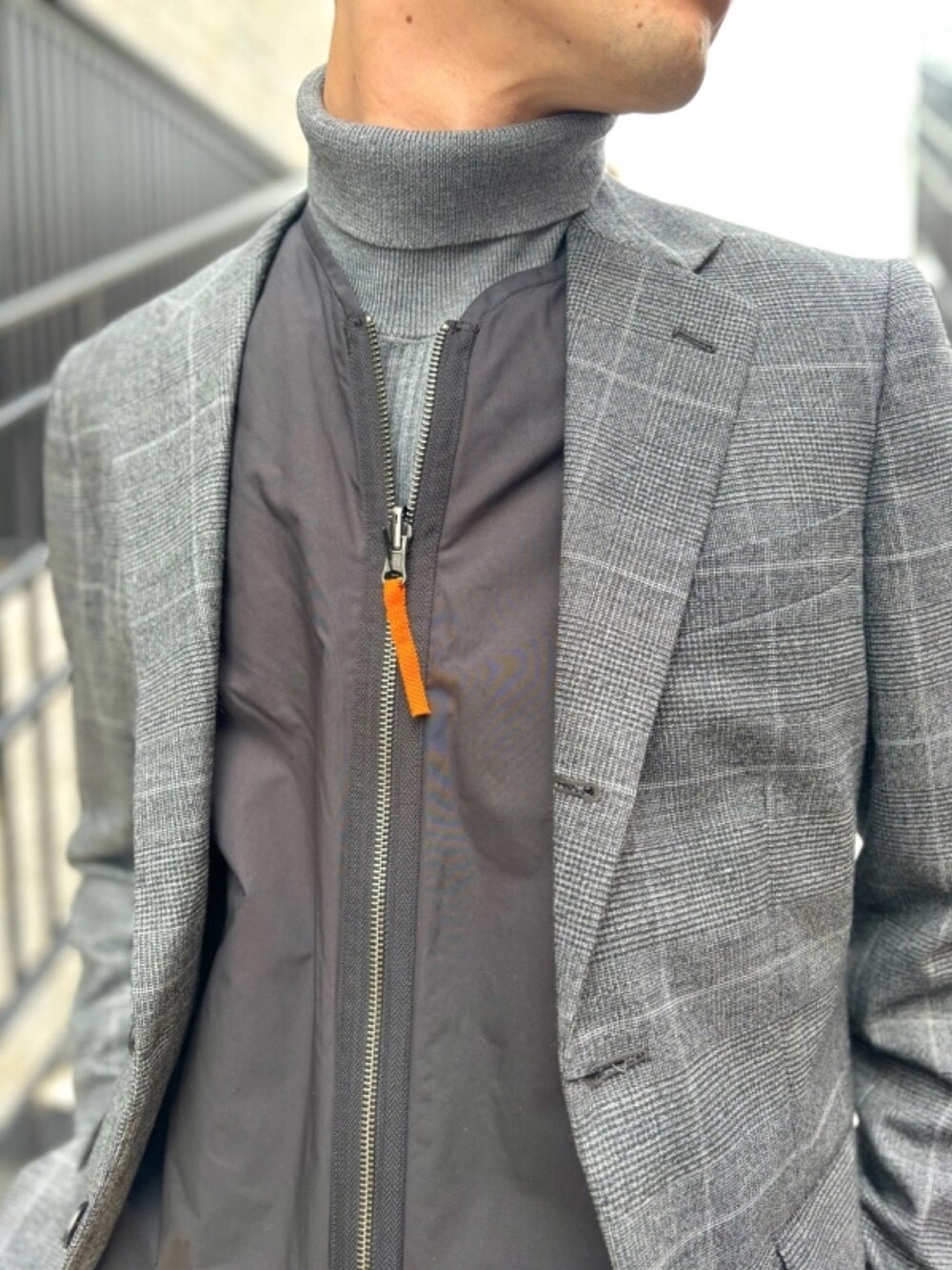 ブラック系のスニーカー、グレー系のスラックス、グレー系のニット/セーターを着用したメンズの冬コーディネートの3枚目の写真