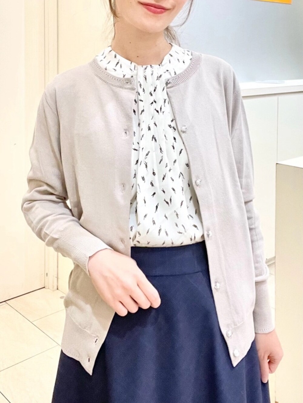 ホワイト系のシャツ/ブラウス、ベージュ系のカーディガン/ボレロを着用したレディースの春コーディネートの2枚目の写真