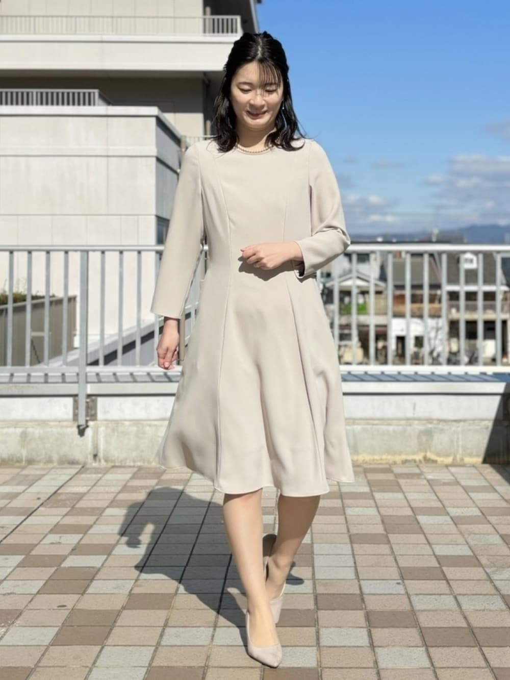 ベージュ系のワンピース、ベージュ系のノーカラージャケットを着用したレディースの冬コーディネートの2枚目の写真