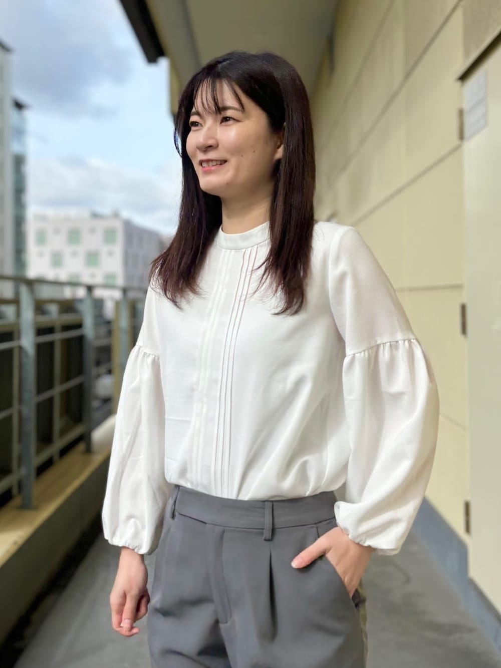 ベージュ系のスーツジャケット、ホワイト系のシャツ/ブラウス、グレー系のスーツパンツを着用したレディースの春コーディネートの5枚目の写真