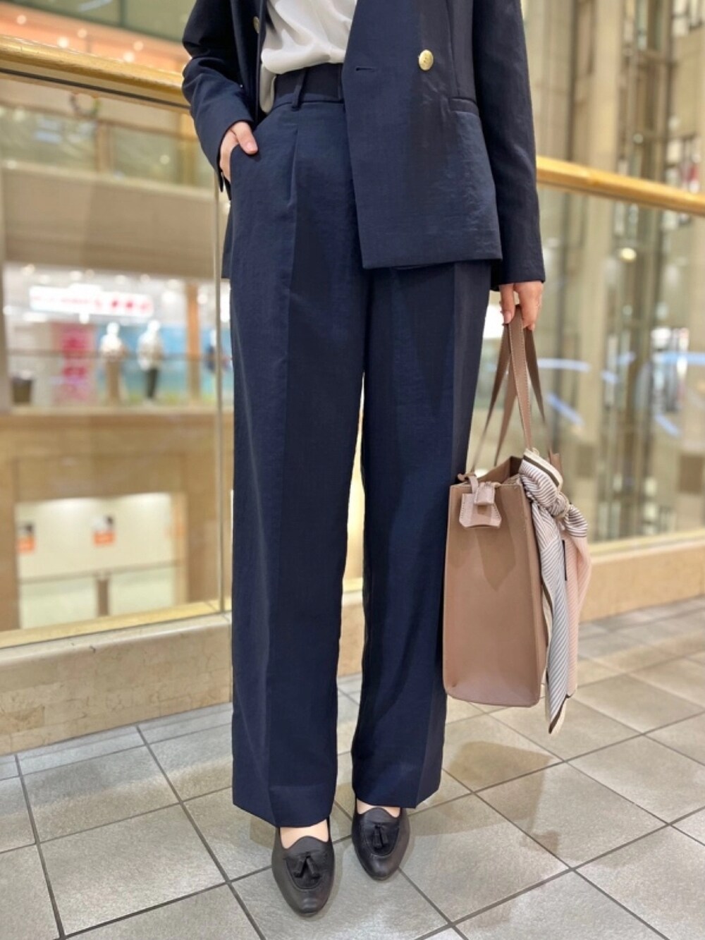 ブルー系のスーツジャケット、ホワイト系のシャツ/ブラウス、ブルー系のスーツパンツを着用したレディースの春コーディネートの3枚目の写真