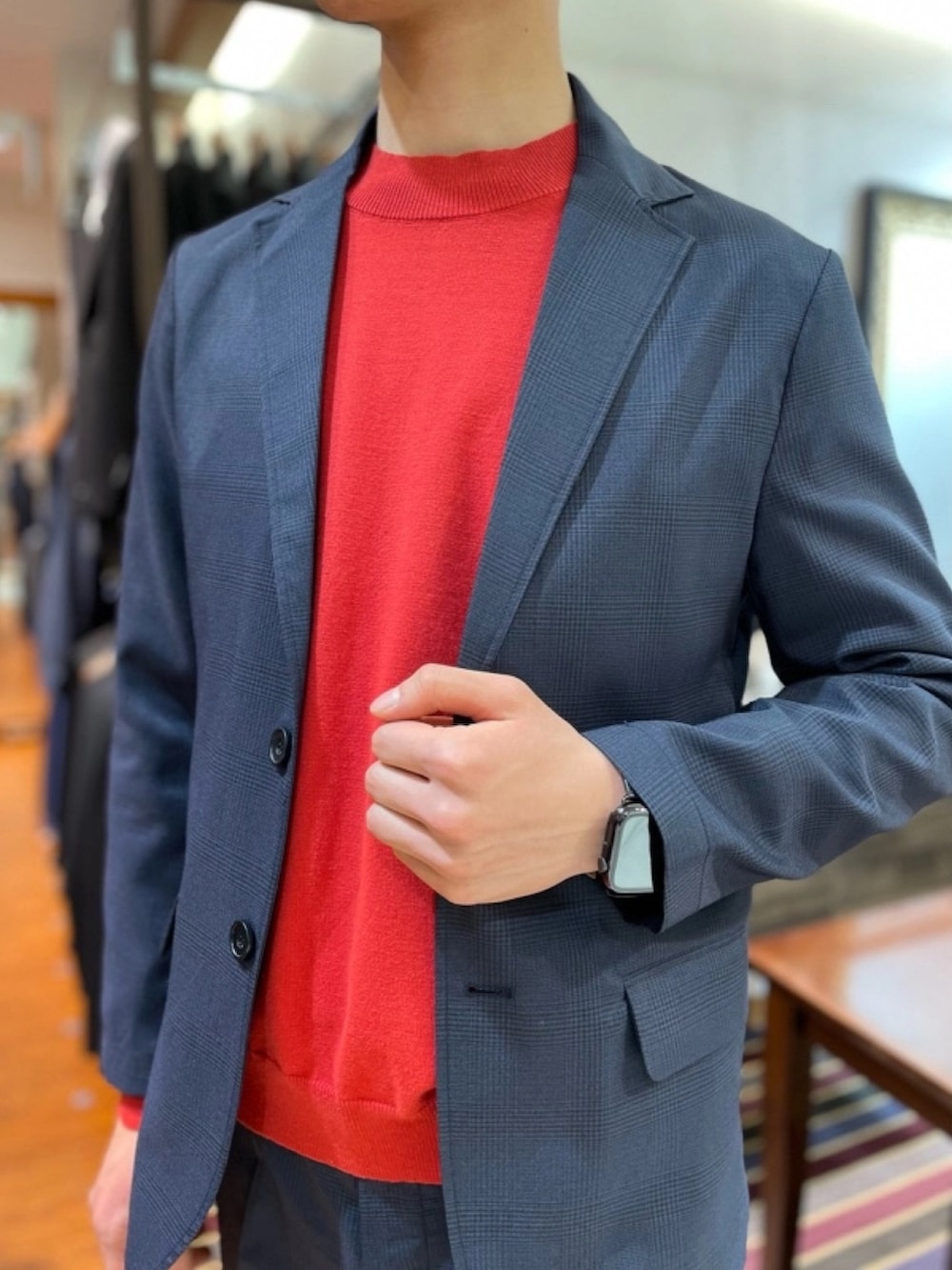ブルー系のテーラードジャケット、レッド系のニット/セーター、ブルー系のスラックスを着用したメンズの春コーディネートの3枚目の写真
