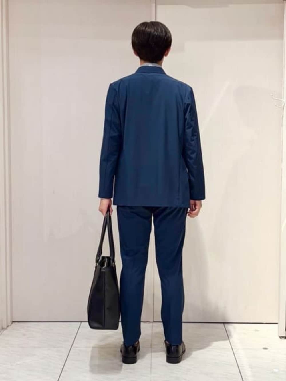 ブルー系のスーツセット、ブルー系のビジネスシャツ、ブラック系のビジネスバッグを着用したメンズの秋コーディネートの4枚目の写真