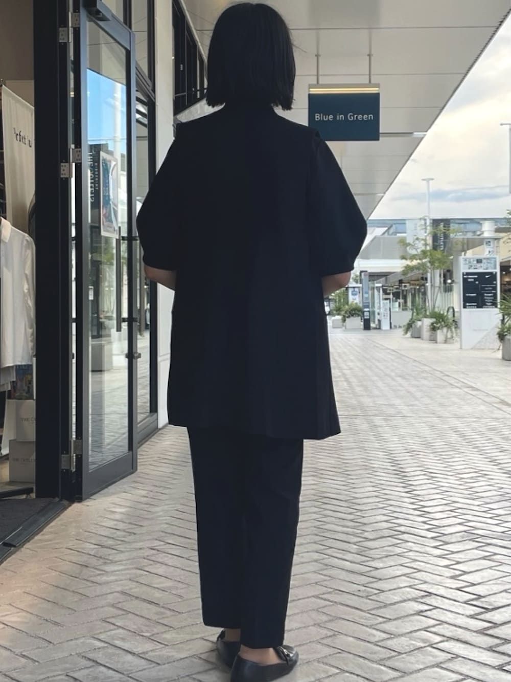 ブラック系のシャツ/ブラウス、ブラック系のベスト、ブラック系のスラックスを着用したレディースの夏コーディネートの2枚目の写真