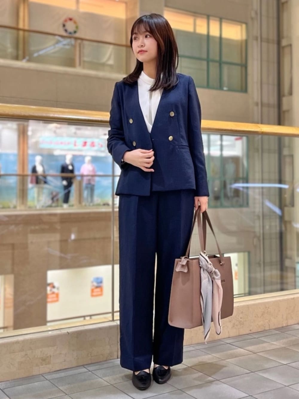 ブルー系のスーツジャケット、ホワイト系のシャツ/ブラウス、ブルー系のスーツパンツを着用したレディースの春コーディネートの2枚目の写真